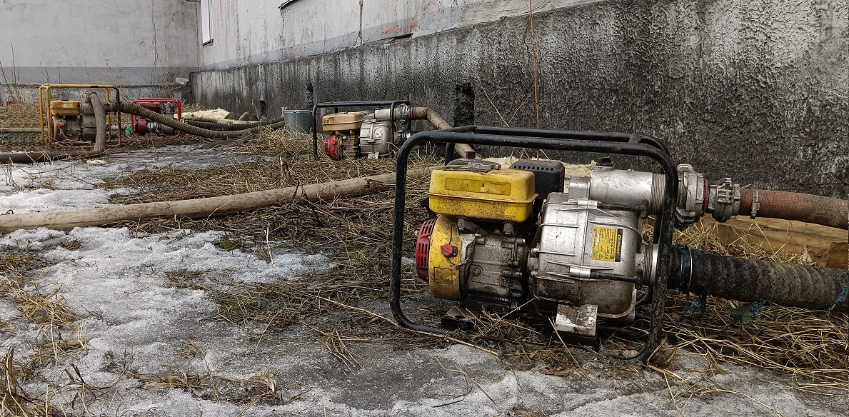 Откачка мотопомпами талой воды из подвала дома в Кировске